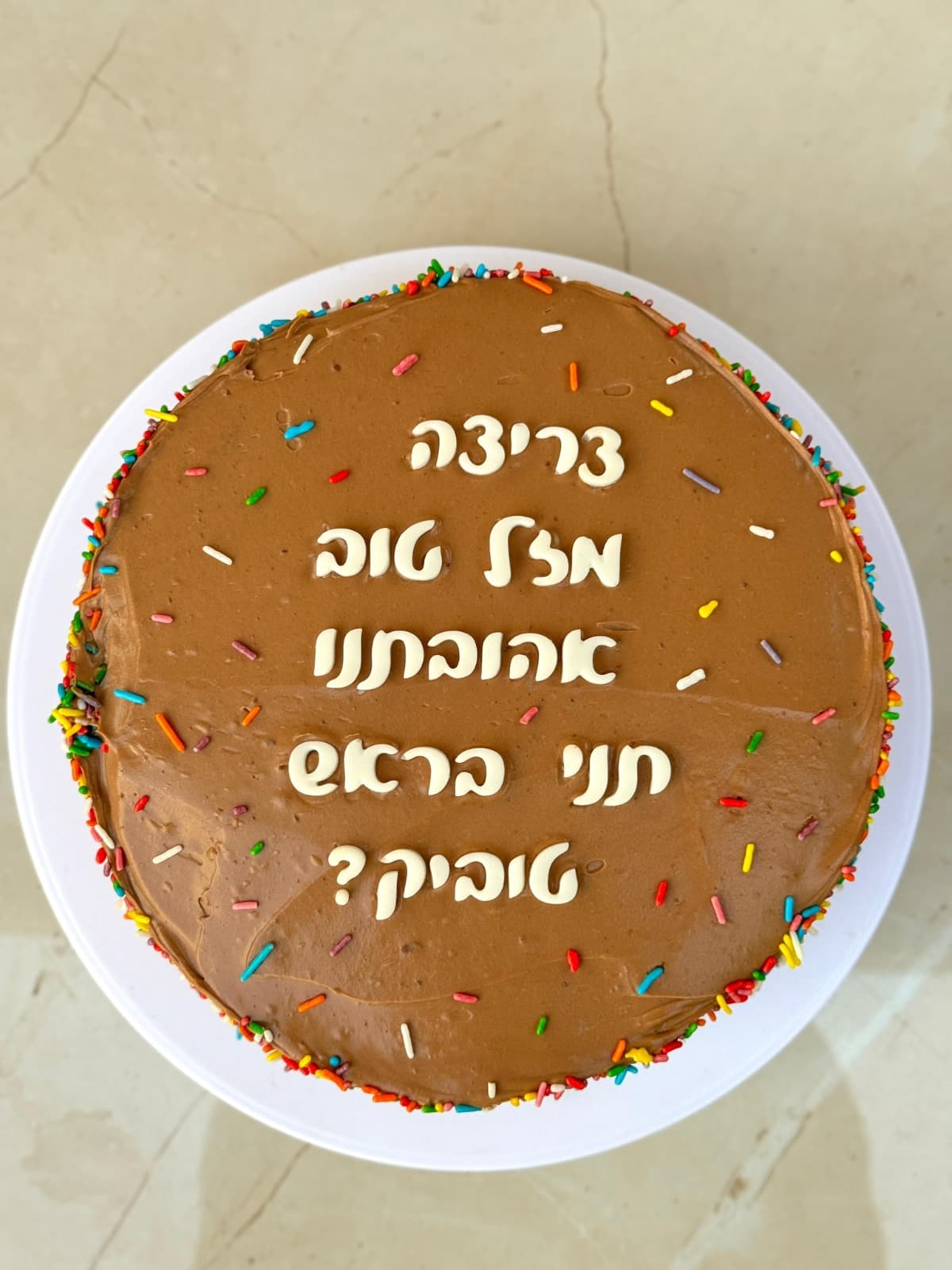 עוגת יום הולדת עגולה עם כיתוב ברכה ופתיתי סוכר צבעוניים